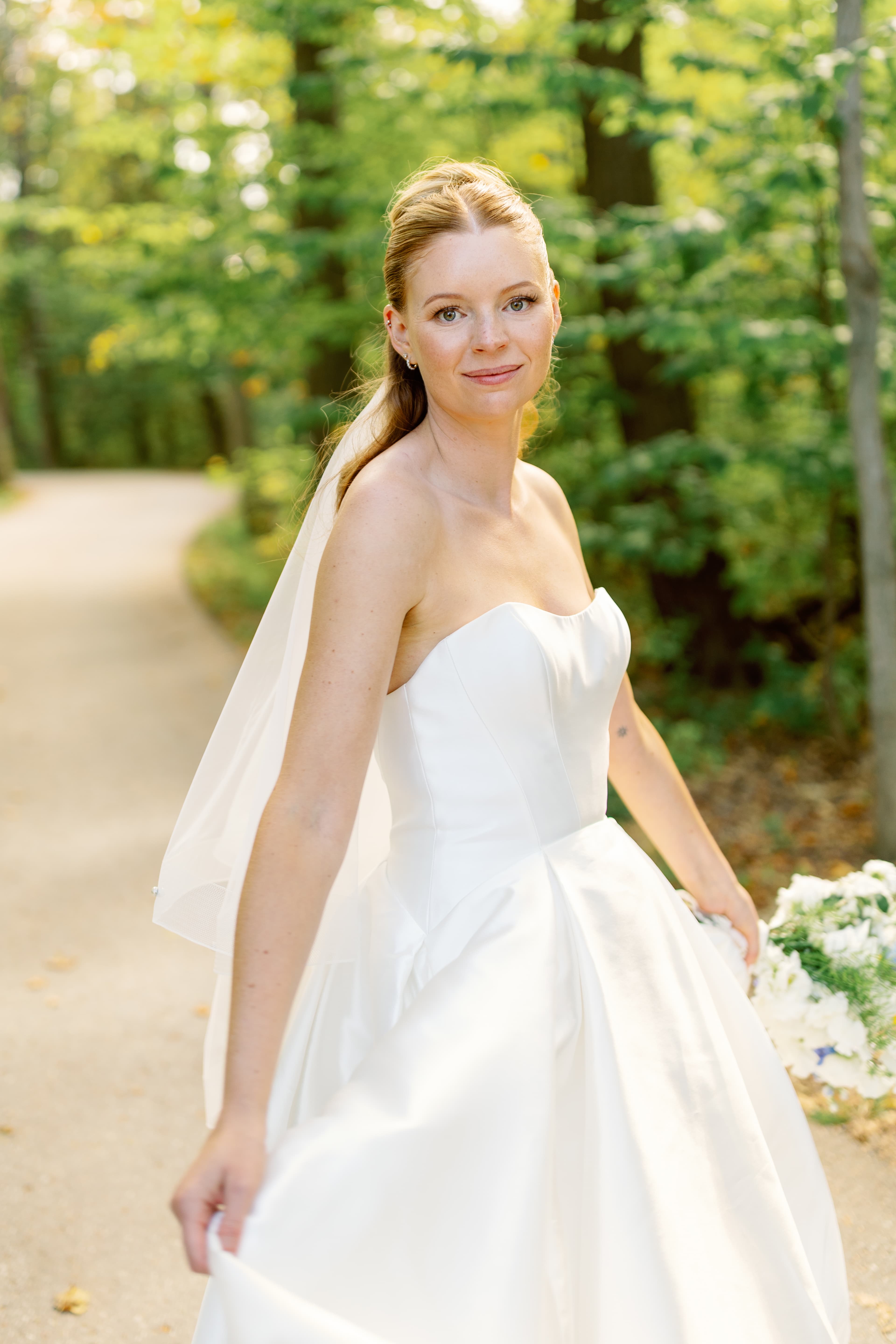 Bride walking down a golden garden path in warm sunlight