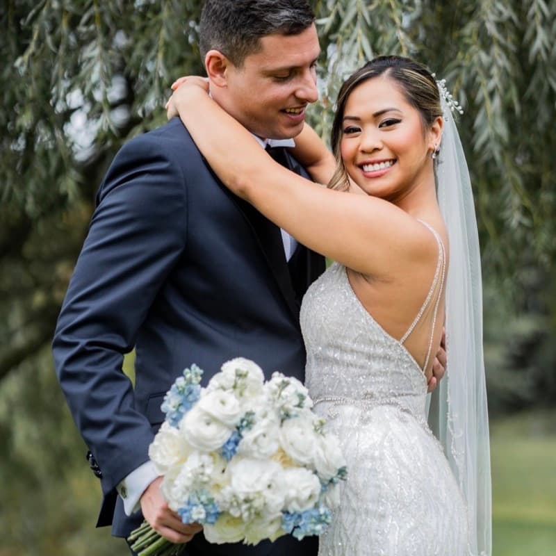 Couple laughing together under a willow tree